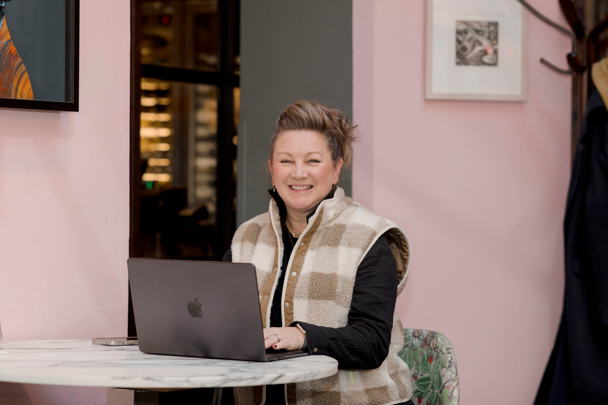 Person (Helen) sitting at a table with a laptop in a casual setting